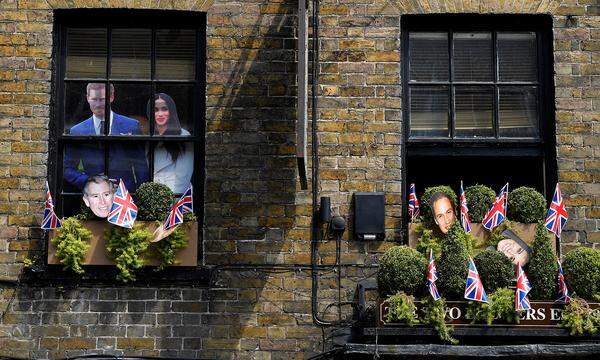Jö schau, wer späht denn da aus dem Fenster des Pubs? Waschechte Fans des britischen Königshauses haben ihre Häuser mit Flaggen und sogar Pappaufstellern von Prinz Harry und Meghan Markle anlässlich der Trauung geschmückt.