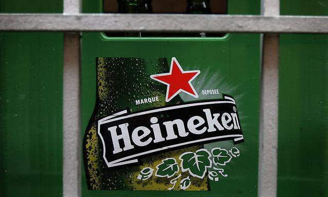 A plastic container with empty bottles of Heineken beers are pictured among beer kegs outside a restaurant in Singapore