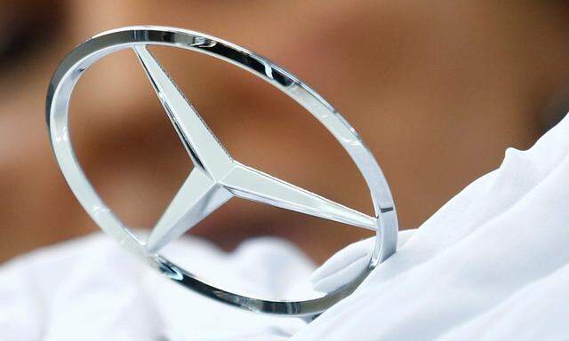 An employee of German car manufacturer Mercedes Benz installs the brand's characteristic star on a Mercedes S-Class (S-Klasse) at a production line at the Mercedes Benz factory in Sindelfingen