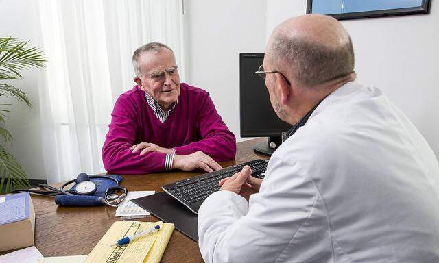 Arztpraxis aelterer Patient im Gespraech mit seinem Hausarzt
