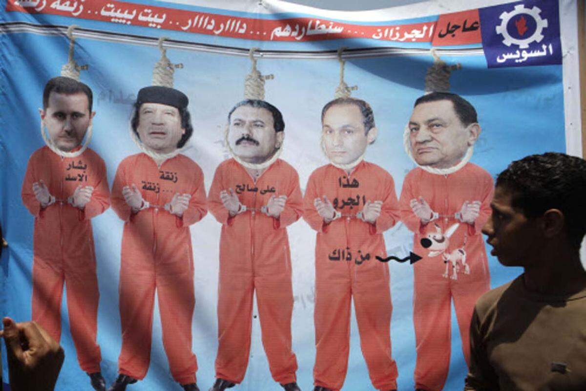 Auch wenn sein Aufenthaltsort bis zuletzt geheim blieb, schon jetzt steht fest, wie sich große Teile des syrischen Volks Assads Ende wünschen: Am Galgen. Im Bild: Plakat mit (v.r.n.l.) Ägyptens Ex-Herrscher Mubarak, sein Sohn Gamal, der jemenitische Präsident Ali Abdullah Saleh und Libyens Machthaber Gaddafi sowie Assad in Gefängniskleidung am Galgen.