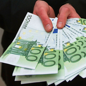 Mann mit Euroscheinen bietet Geld an