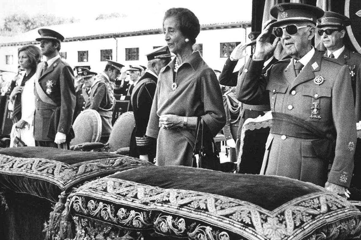 Dabei hat die Monarchie in Spanien traditionell keinen leichten Stand. In der Ersten und Zweiten Republik sowie während der Franco-Diktatur (1939-1975) hatte das Land keinen König. Der im Exil in Rom geborene Juan Carlos wurde nach dem Tod des Diktators Franco 1975 spanischer König. Diktator Franco salutiert neben seiner Frau Carmen Polo (2.v.r.), rechts von ihnen steht Prinz Juan Carlos und Prinzessin Sofia, 1975.