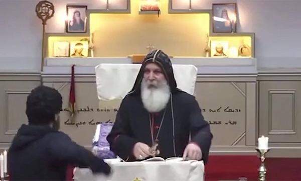 Ein Mann stürmt auf den bekannten assyrischen Bischof Mar Mari Emmanuel los.
