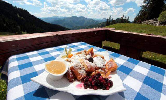 Teller mit Kaiserschmarrn und Kompott sowie Obst steht auf einem in den Landesfarben Bayern s gedeck