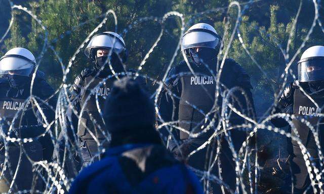 Belarus Poland Border Refugees 6692091 09.11.2021 Polish policemen guard the border near an illegal migrant camp on the
