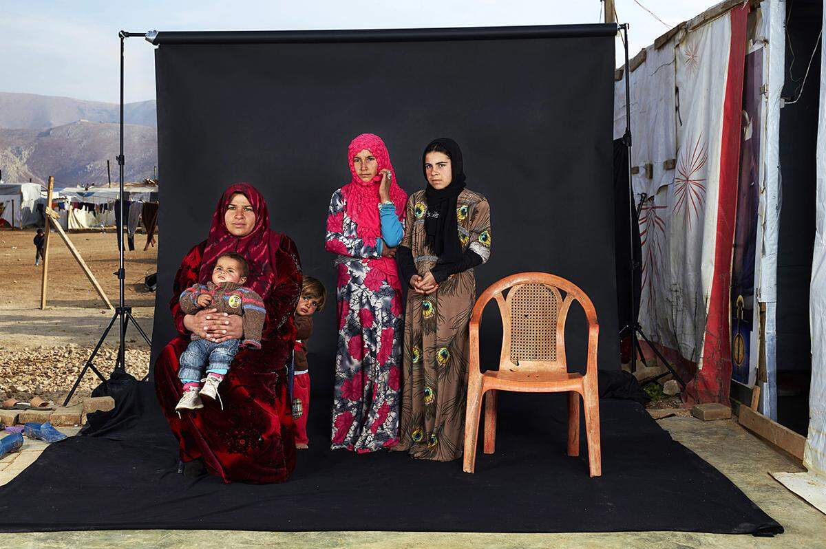 Dario Mitidieri, Italien, 2015, Aus der Serie "Lost Family Portraits": Porträt einer syrischen Familie im Flüchtlingscamp Bekaa Valley, Libanon, am 15. Dezember 2015. Der leere Sessel steht für ein Familienmitglied, das entweder im Krieg gestorben wird oder noch vermisst ist. 