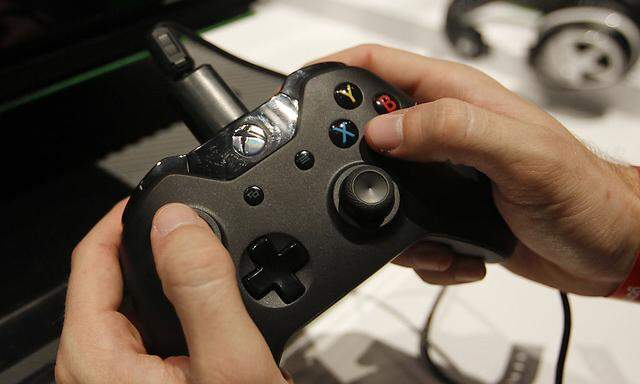 A visitor plays the Xbox One at the Microsoft Games exhibition stand during the Gamescom 2013 fair in Cologne
