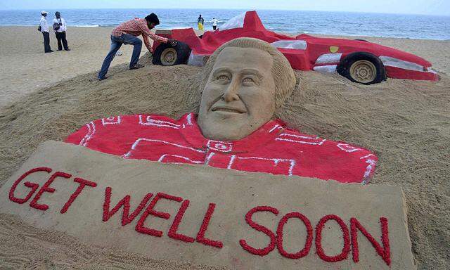 Indian sand artist Pattnaik works on a sand sculpture of Schumacher at Puri