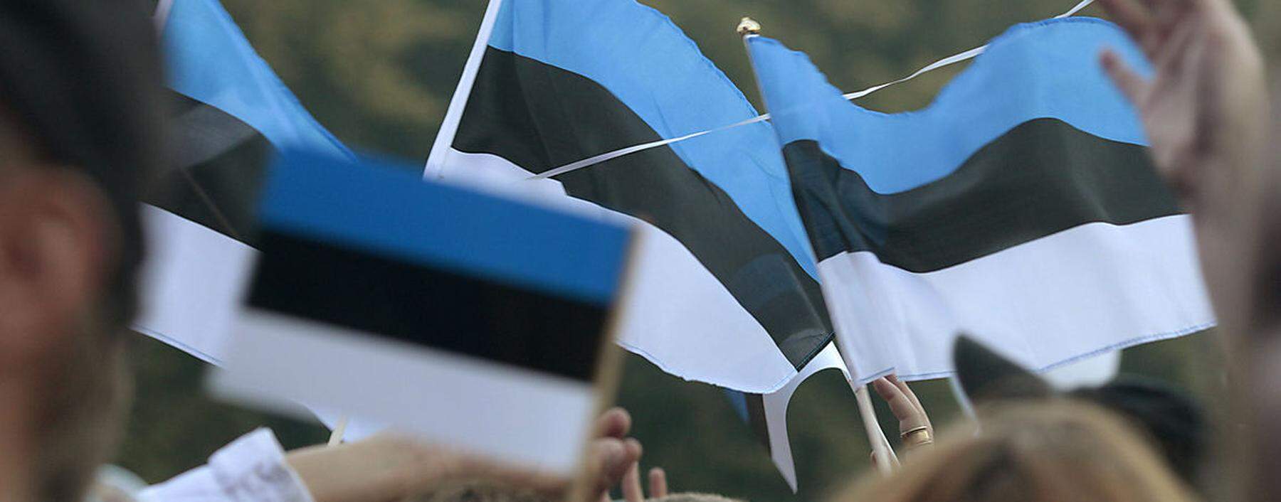 People wave Estonian national flags as they watch ´Song of Freedom´ concert in Tallinn