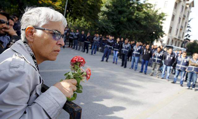 A demonstrator holds flowers near a police barricade during a commemoration for the victims of Saturday´s bomb blasts in the Turkish capital, in Ankara
