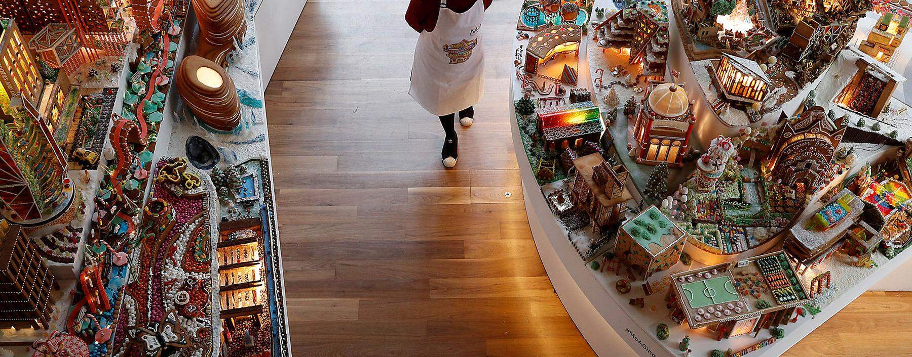 A staff member poses for a photograph next to the Museum of Architecture´s Gingerbread City at the V&amp;A Museum, in London
