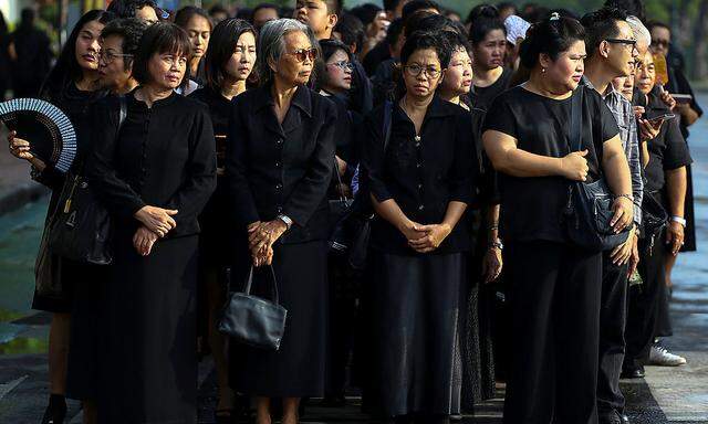 Thailänder stellen sich an, um König Bhumibol zu ehren.