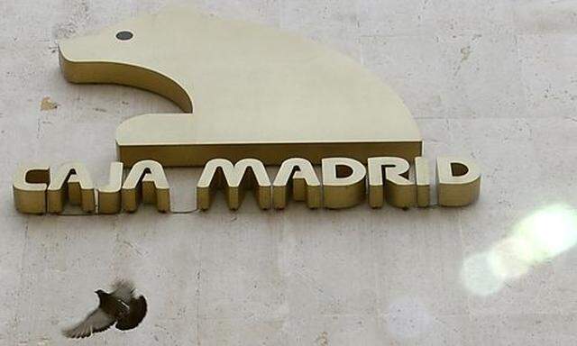 A pigeon flies close to the logo of Spanish savings bank Caja Madrid in downtown Madrid