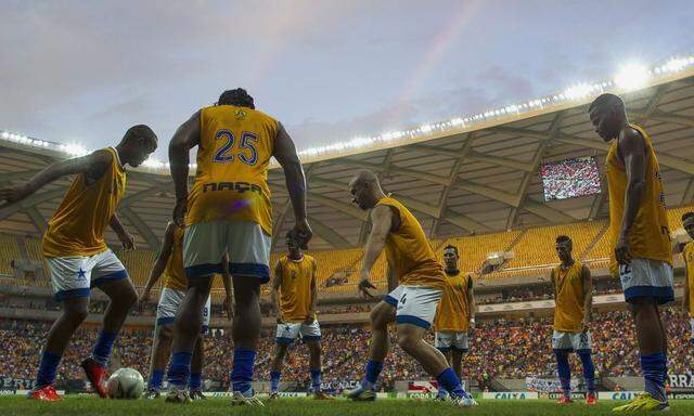 Players warm up in the Arena Amazonia Vivaldo Lima soccer stadium in Manaus