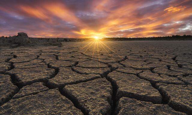 From above of drought cracked lifeless ground under colorful cloudy sky at sunset time Copyright: xJuanxLopezx