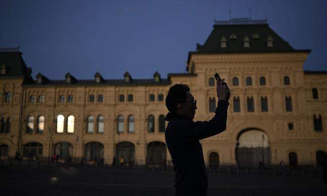 Archivbild. Ein Tourist auf dem Roten Platz in Moskau hantiert mit seinem Smartphone.