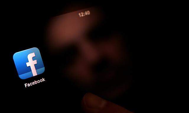 FILE PHOTO: A man uses an iPad with a Facebook app in this photo illustration in Sofia