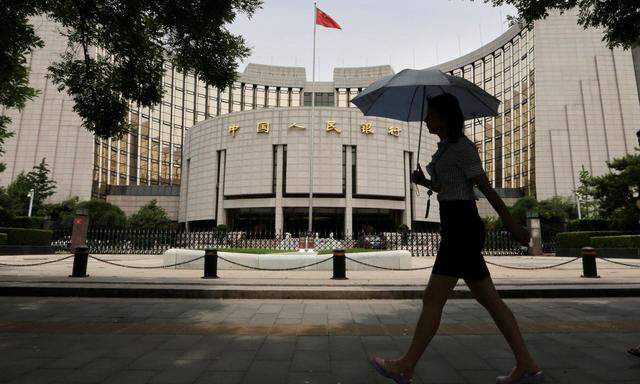 Woman walks past the headquarters of the PBOC in Beijing