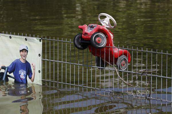 Ein Spielzeugauto hängt in einem Zaun in Fischerdorf, einem kleinen Vorort von Deggendorf.