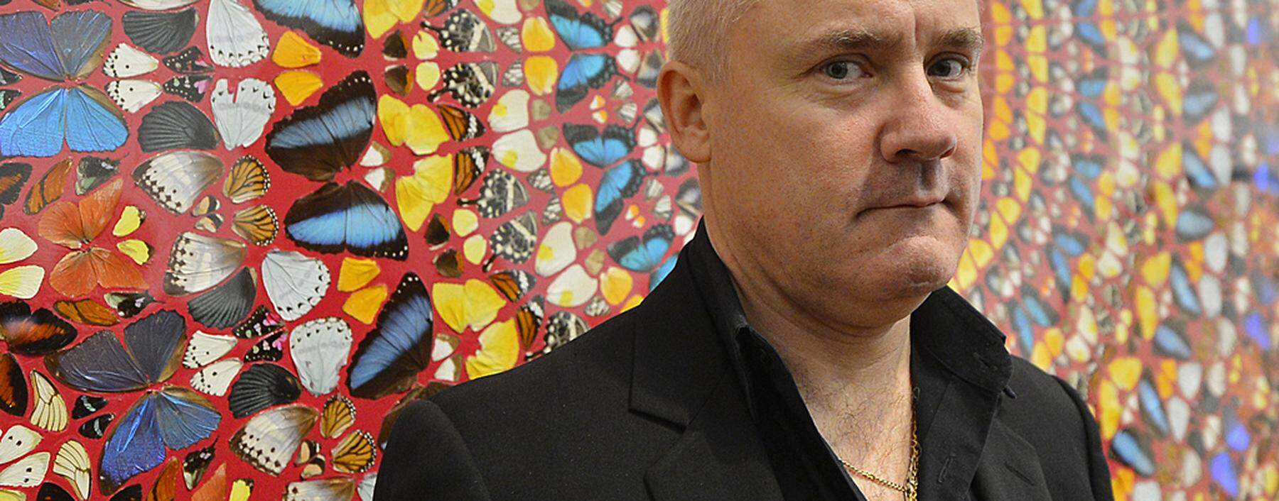 British artist Damien Hirst poses next to his painting ´I Am Become Death, Shatterer of Worlds´, at the Tate Modern gallery in London