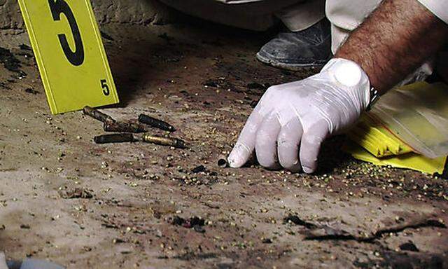 In this Sunday, March 11, 2012 image made from video, bullet casings are seen as an investigator work