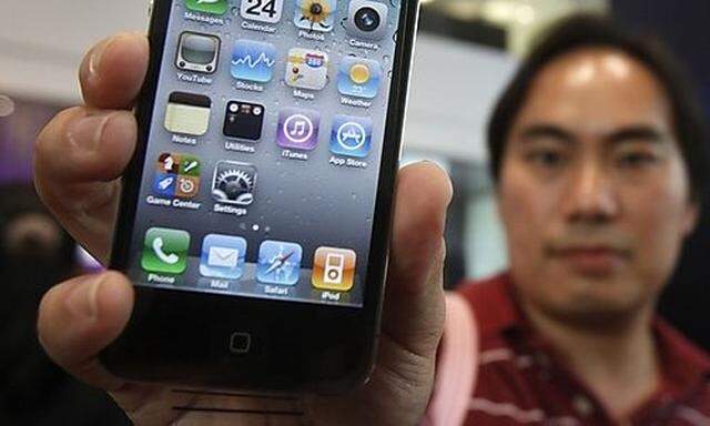 Boonchu Juramongkol, 34, shows his new iPhone 4 at a shop in Bangkok