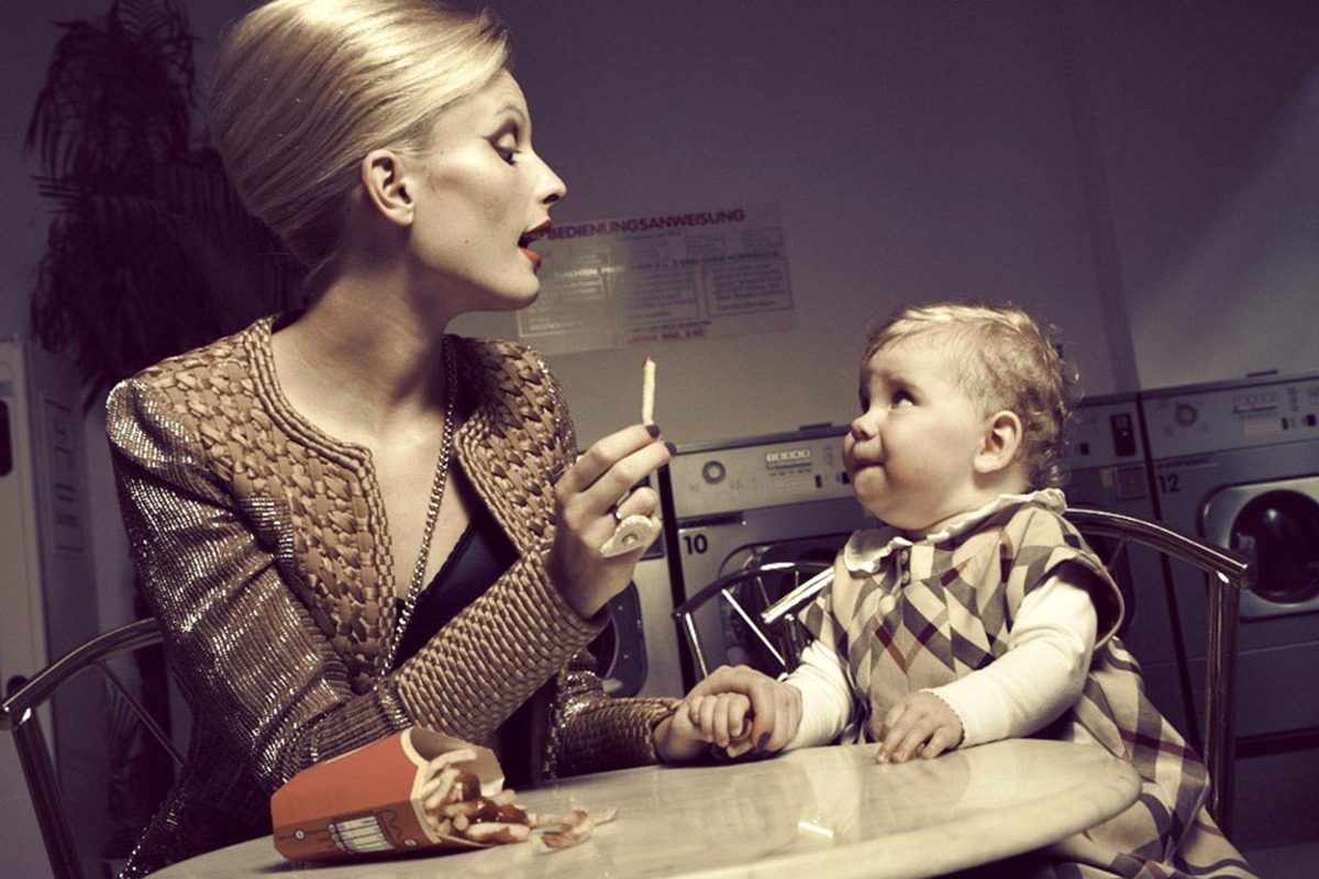 Mantel um 6760 Euro von Gianfranco Ferré, BH von Dolce & Gabbana, Preis auf Anfrage, schräg getragene Handytasche um 525 Euro von Dolce & Gabbana, Ring um 47.788 Euro von Kornmesser; Kind: Kleid um 129 Euro von Burberry bei Jennings, Longsleeve um 24,50 Euro von Käthe Kruse.