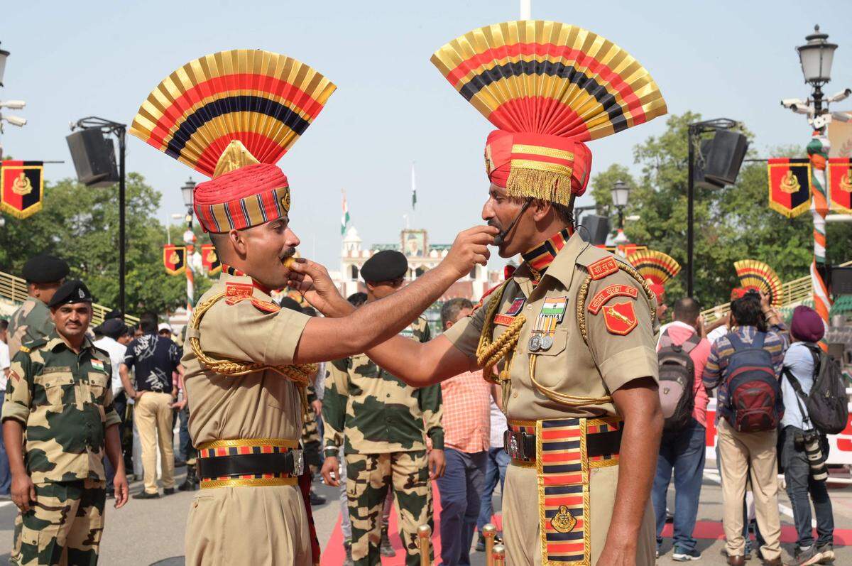 15. August. Soldaten an der Grenze zu Pakistan feiern den 77.Jahrestag der Unabhängigkeit Indiens in einer kleinen synchronisierten Zeremonie auf besondere Art: Sie bieten einander Süßigkeiten an. 