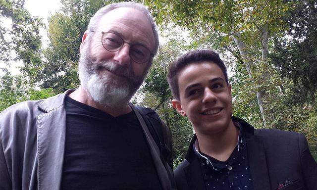 Games of Thrones star Liam Cunningham smiles together with his supporter Syrian migrant Hussam Alheraky as he made a surprise vist in Stuttgart