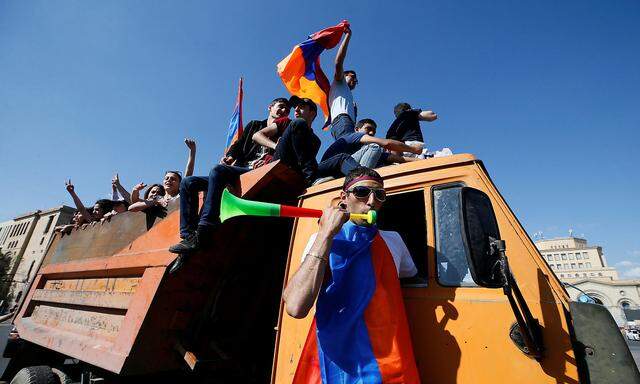 Armenian opposition supporters ride on a truck in Yerevan