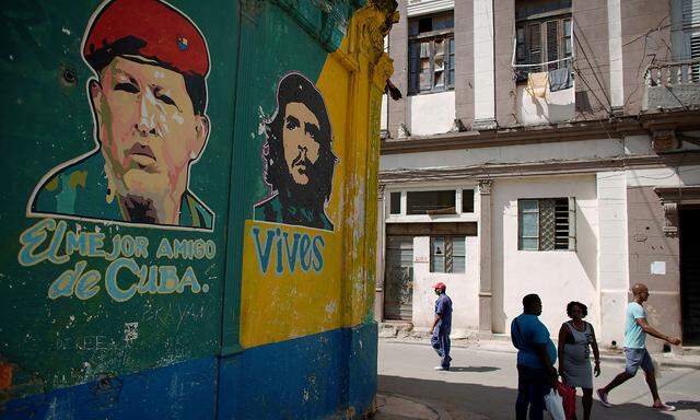 FILE PHOTO: People pass by images depicting Venezuela's late president Chavez and late revolutionary hero 'Che' Guevara in downtown Havana
