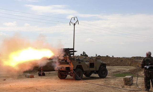 Schiitische Kämpfer feuern eine Rakete in Richtung IS-Stellungen bei Tikrit ab.