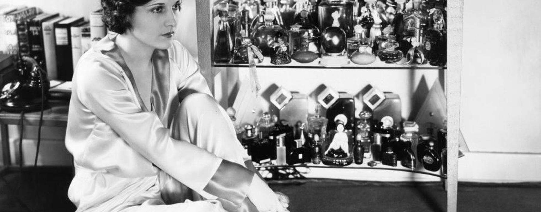 Stummfilmstar Evelyn Brent vor ihrer Parfumsammlung, 1930.