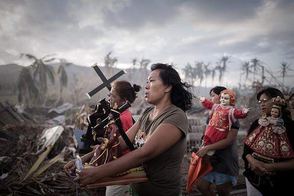 Phillipe Lopez, Frankreich, Agence France-Presse 18. November 2013, Tolosa, Philippinen: Überlebende des Taifuns Haiyan marschieren auf einer Prozession durch Tolosa. Durch den Wirbelsturm starben 8000 Menschen, mehr als vier Millionen wurden obdachlos.HINWEIS: Das nächste Foto zeigt zwei Tote.
