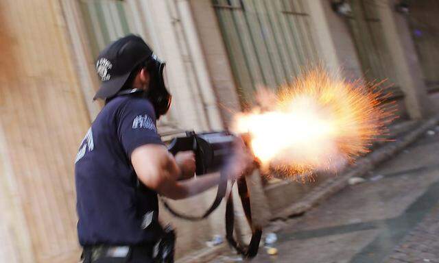 A riot policeman fires teargas during a protest in central Istanbul
