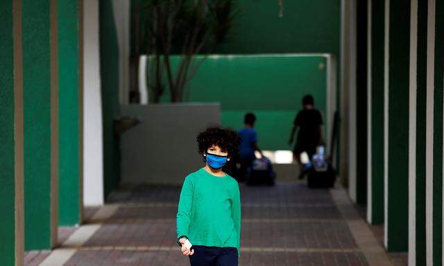 A pupil wearing a protective face mask, looks on as Israel reopens first to fourth grades, continuing to ease a second nationwide coronavirus disease (COVID-19) lockdown, at a school in Rehovot