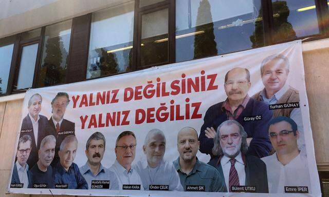 Plakat mit Abbildungen der Mitarbeiter der Zeitung „Cumhuriyet“, denen der Prozess gemacht wird. Die Botschaft: „Ihr seid nicht allein. Wir sind nicht allein.“