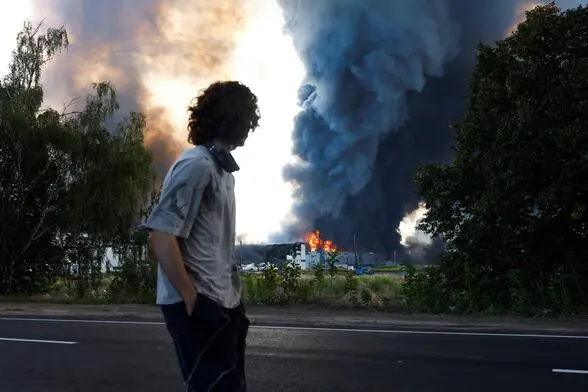 Ein ukrainischer Mann blickt auf ein Warenlager, das von russischen Drohnen attackiert wurde. Das Bild wurde am 27. August 2026 aufgenommen.    