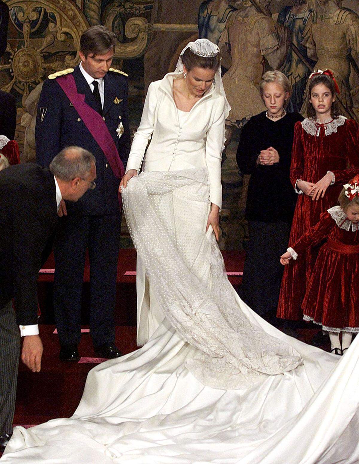 Da das Paar im Dezember heiratete, trug die Braut eine crémefarbene Mantel-Robe und darunter ein schlichtes Kleid. Die Tiara wurde von der Schwiegermutter beigesteuert.