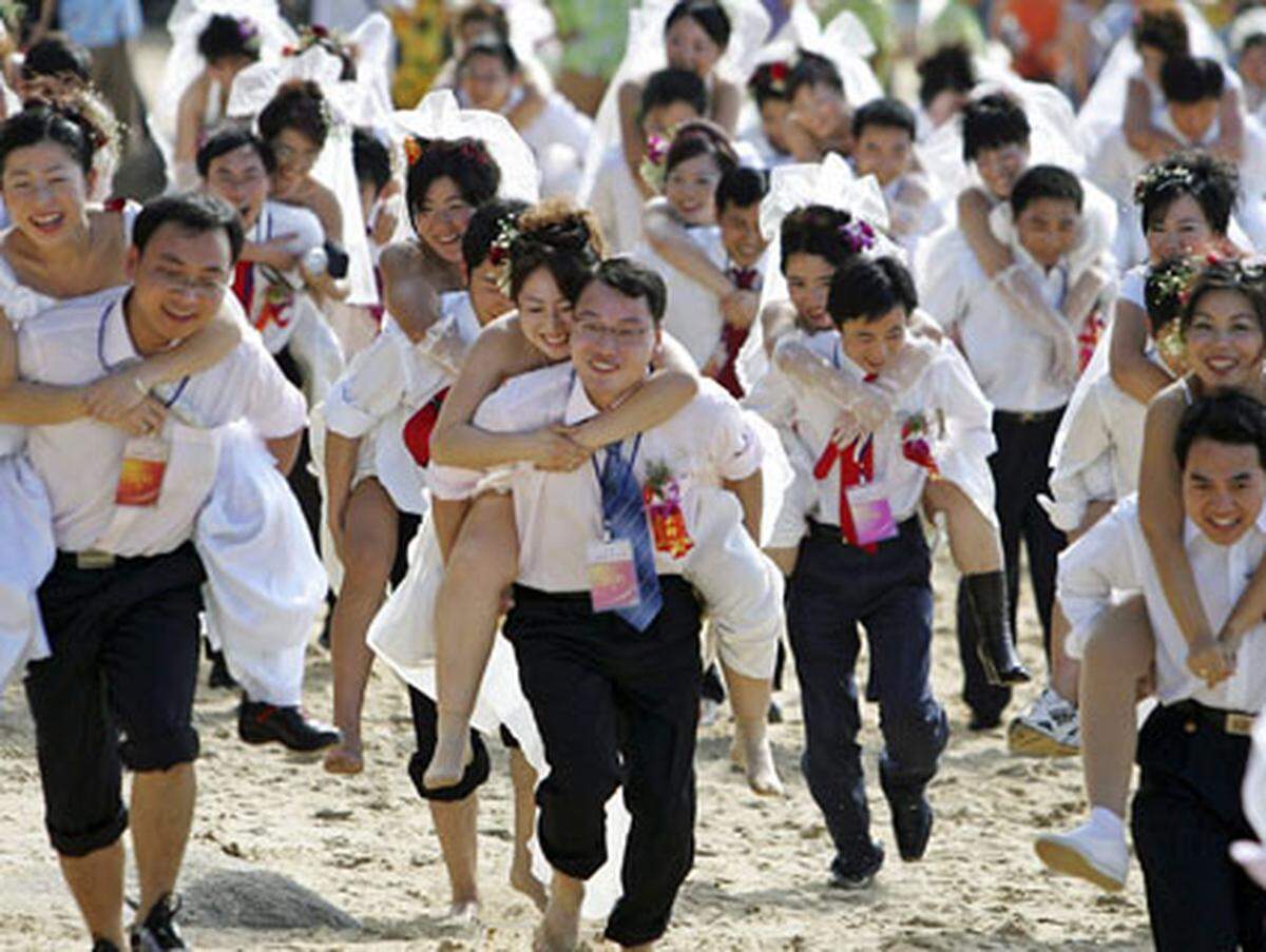 Was hier wie eine Hochzeit aussieht, ist der schwungvolle Beginn des neuen Jahres in Südchina. Huckepack muss der hoffentlich gut trainierte Bräutigam seine Braut nehmen und einen Mini-Marathon absolvieren.