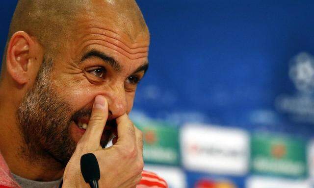 Munich's coach Pep Guardiola pauses during a news conference in Munich