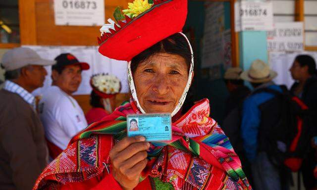 Eine Wählern im "Heiligen Tal der Inkas" im Süden Perus zeigt ihre ID-Karte