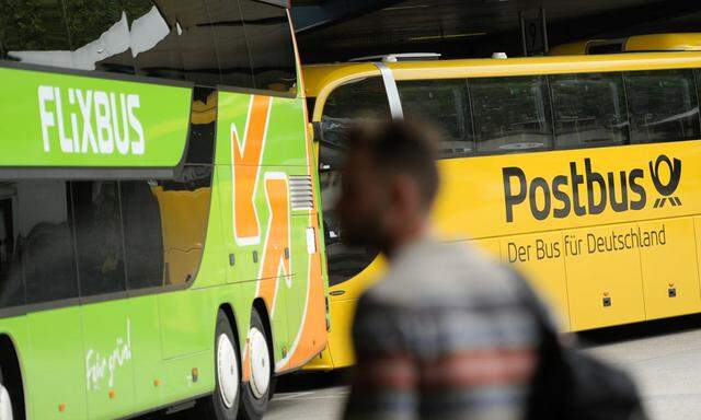 A man walks near Flixbus and Postbus busses at the main bus station in Berlin