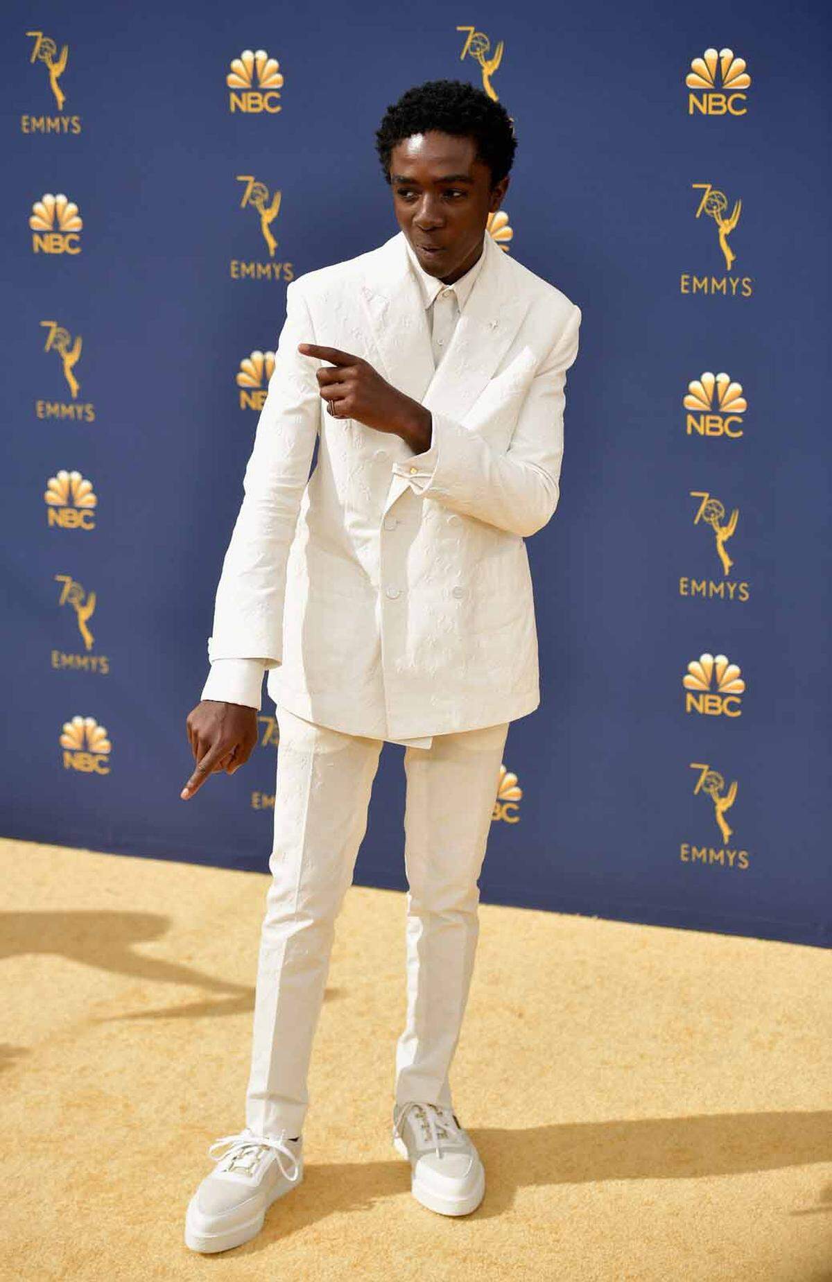 Caleb McLaughlin in einem Outfit von Louis Vuitton und Sneakers zum Auflockern.