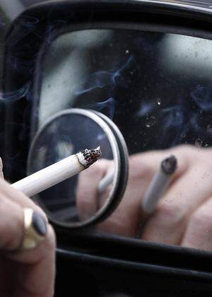 A man smokes a cigarette as he sits in his car in Liverpool