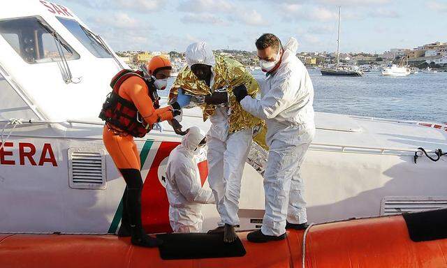 Einer der Überlebenden des Bootsunglücks wird in Lampedusa an Land gebracht.