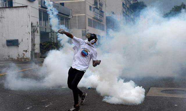 Demonstranten werfen Tränengas gegen die Polizei in Caracas.