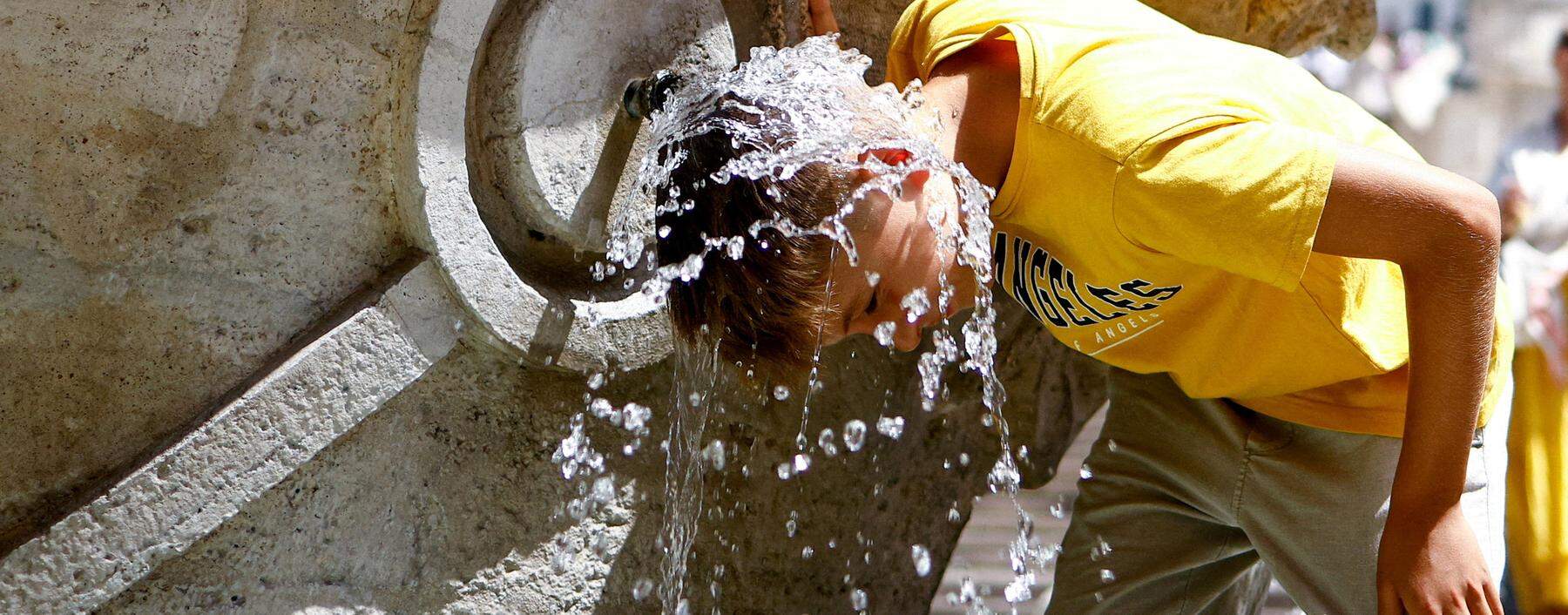 FILE PHOTO: A boy cools off at Fontana della Barcaccia at the Spanish Steps during a heat wave across Italy as temperatures are expected to rise further in the coming days, in Rome, Italy July 17, 2023. REUTERS/Guglielmo Mangiapane     TPX IMAGES OF THE DAY/File Photo