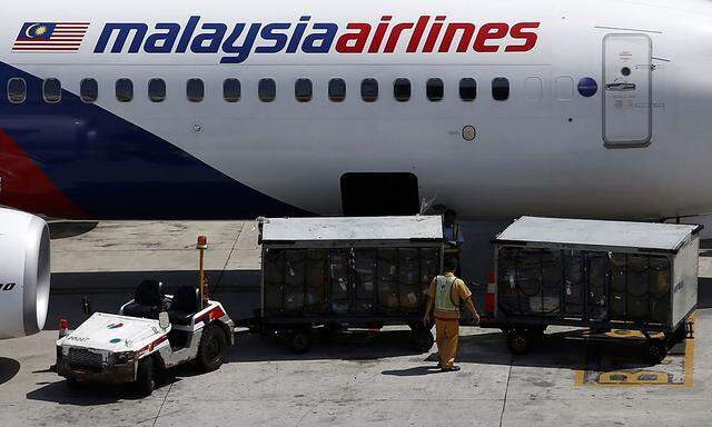 File photo of serviceman loading luggage into Malaysia Airlines plane at Kuala Lumpur International Airport in Sepang